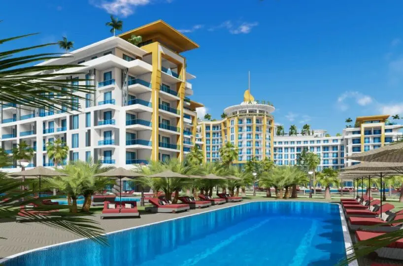 Two-room apartment for sale in Türkler Alanya – exterior view of the residential complex with sea in the background